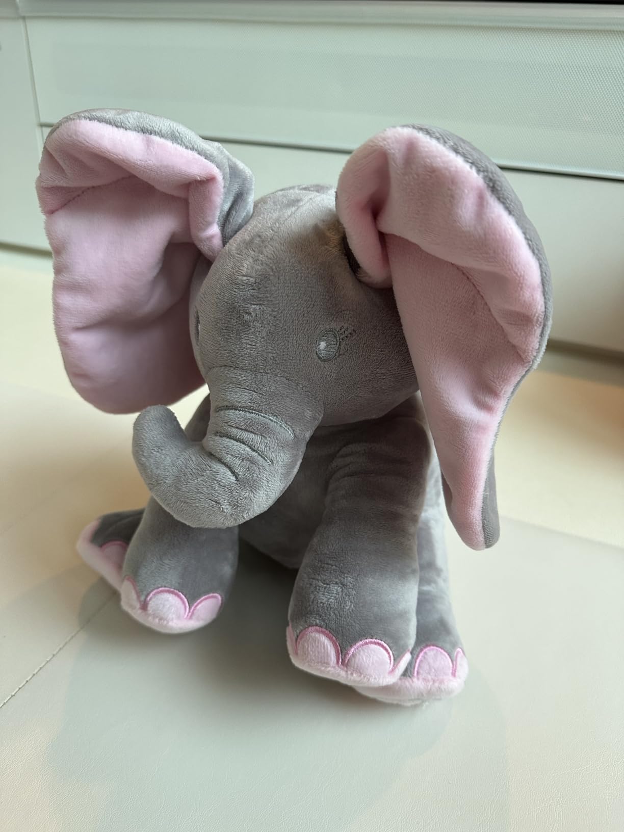 Plush elephant toy with pink accents on a light background